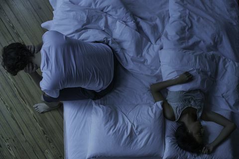 אדם במיטה סובל מבעיות שינה בלילה