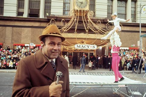 ג'ו גראג'ולה מדבר למיקרופון עם אקרובטים ברקע במצעד חג ההודיה של מייסי ב-1970