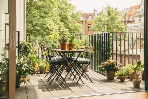 כיסאות ביסטרו ושולחן במרפסת עם נוף בחצר