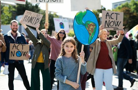 אנשים עם שלטים ופוסטרים על שביתה עולמית למען שינויי אקלים.