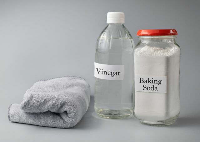 תקריב של חומץ וסודה לשתייה טקסט על בקבוק זכוכית על רקע אפור