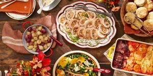 שולחן ערוך עם צלחות אוכל כולל רולדת הודו, סלט חורף, ביסקוויטים, גרטן ירקות שורש ובצל חמוץ מתוק