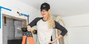 ביתו של גיילי אליקס מהבית של hgtv בדופק עומד על סולם לבושה בכובע כדורי ג'ינס מנוזי צבע